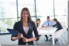 business woman with her staff in background at office